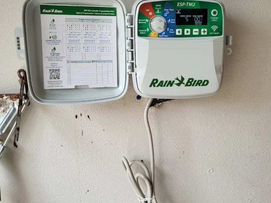 Smart sprinkler controller mounted on a garage wall
