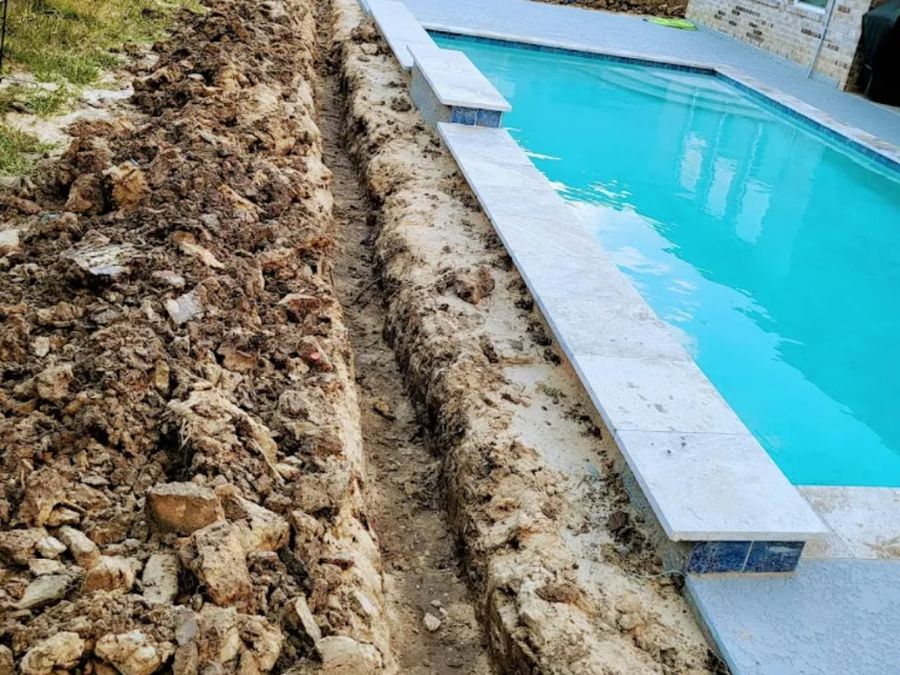 Irrigation line trench running alongside a pool